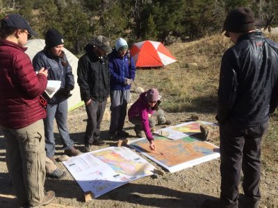 Geology students looking at a map in the field